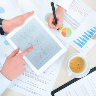 Business Analytics Business team analyzing income charts and graphs with modern digital tablet. Top view photoshoot.